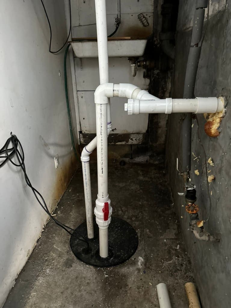 PVC drain line with a cleanout in a basement, installed by MRJ Plumbing near Asheville, NC