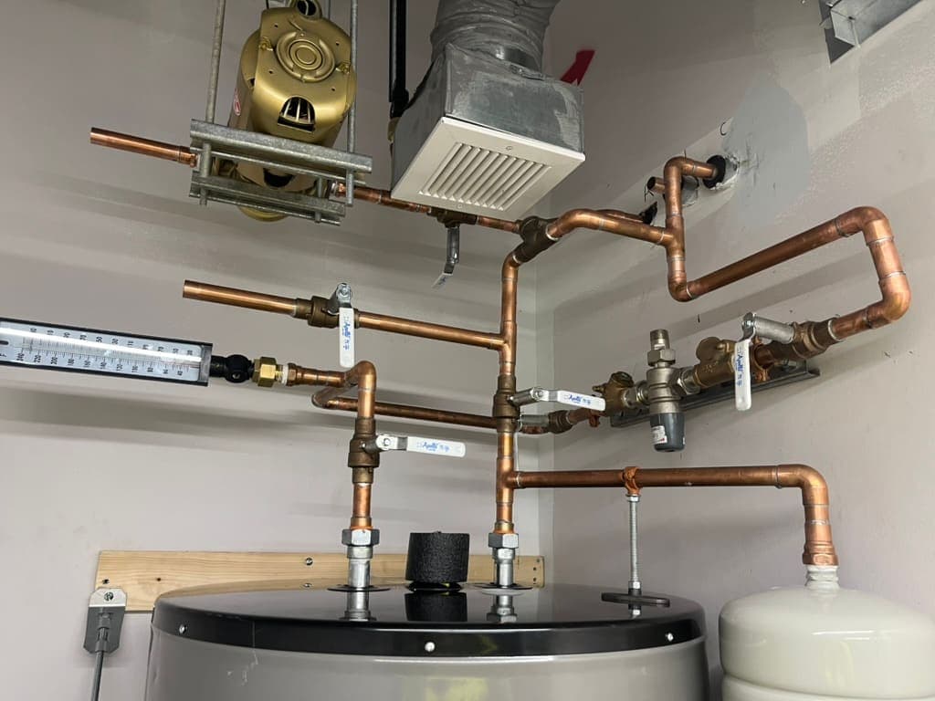 Copper supply piping, valves, and expansion tank on a water heater installed by MRJ Plumbing in Asheville, NC