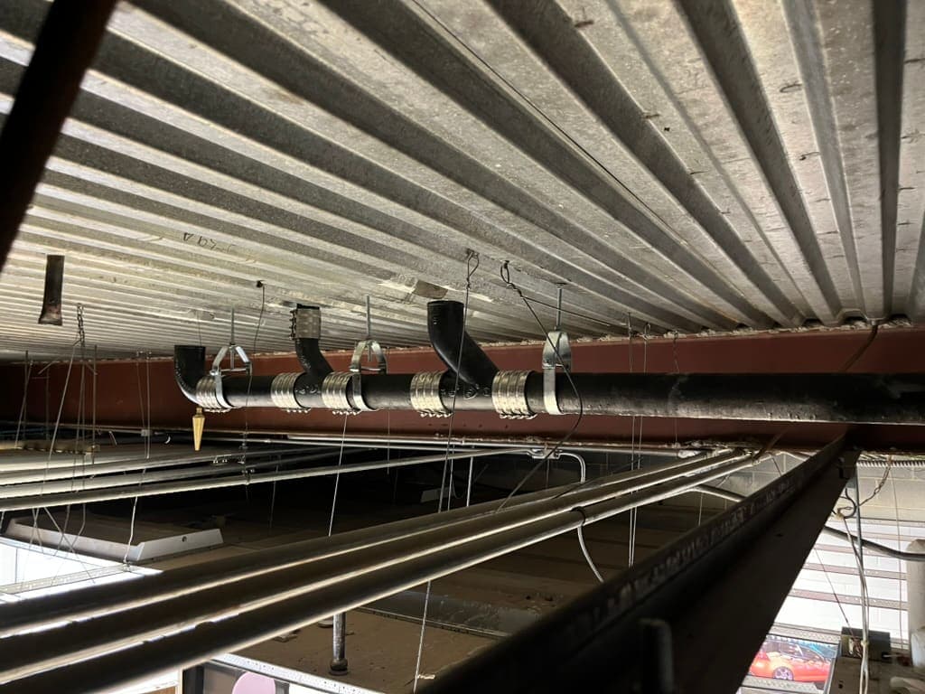 Copper and drain lines in a commercial ceiling, a plumbing job by MRJ Plumbing in the Asheville, NC area