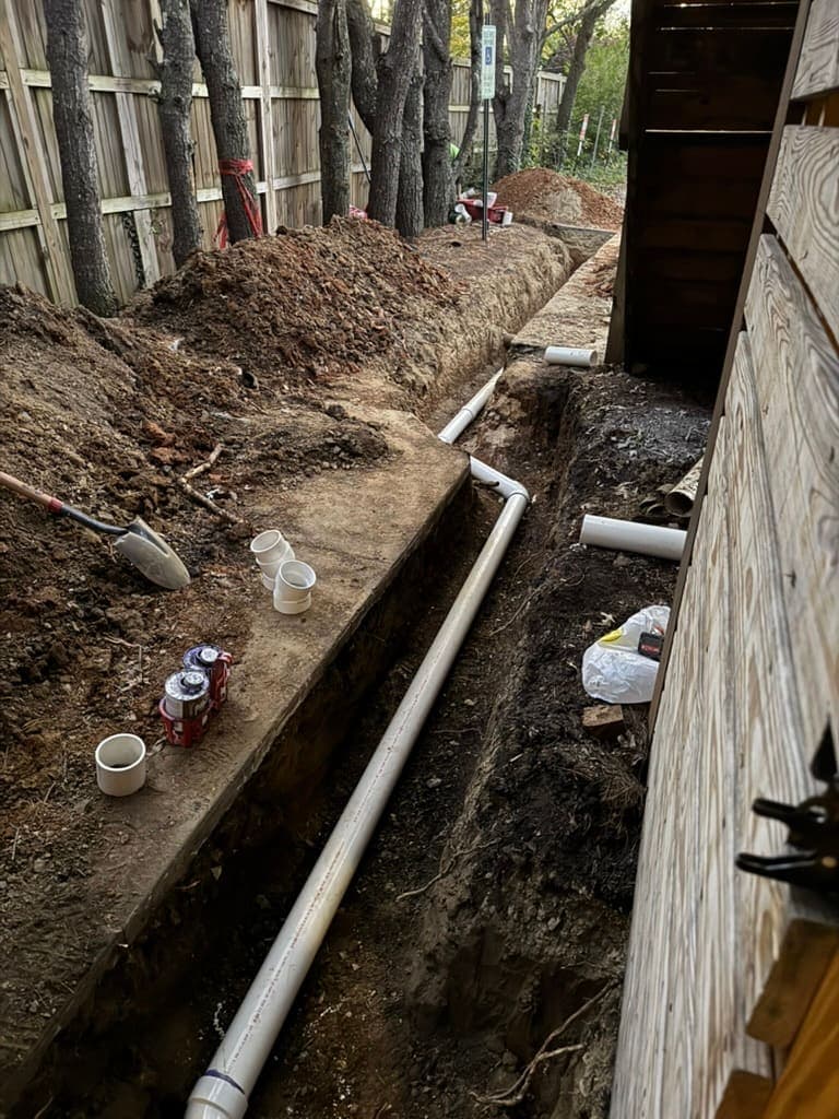 Drain line trench along a foundation, a plumbing job by MRJ Plumbing in the Asheville, NC area