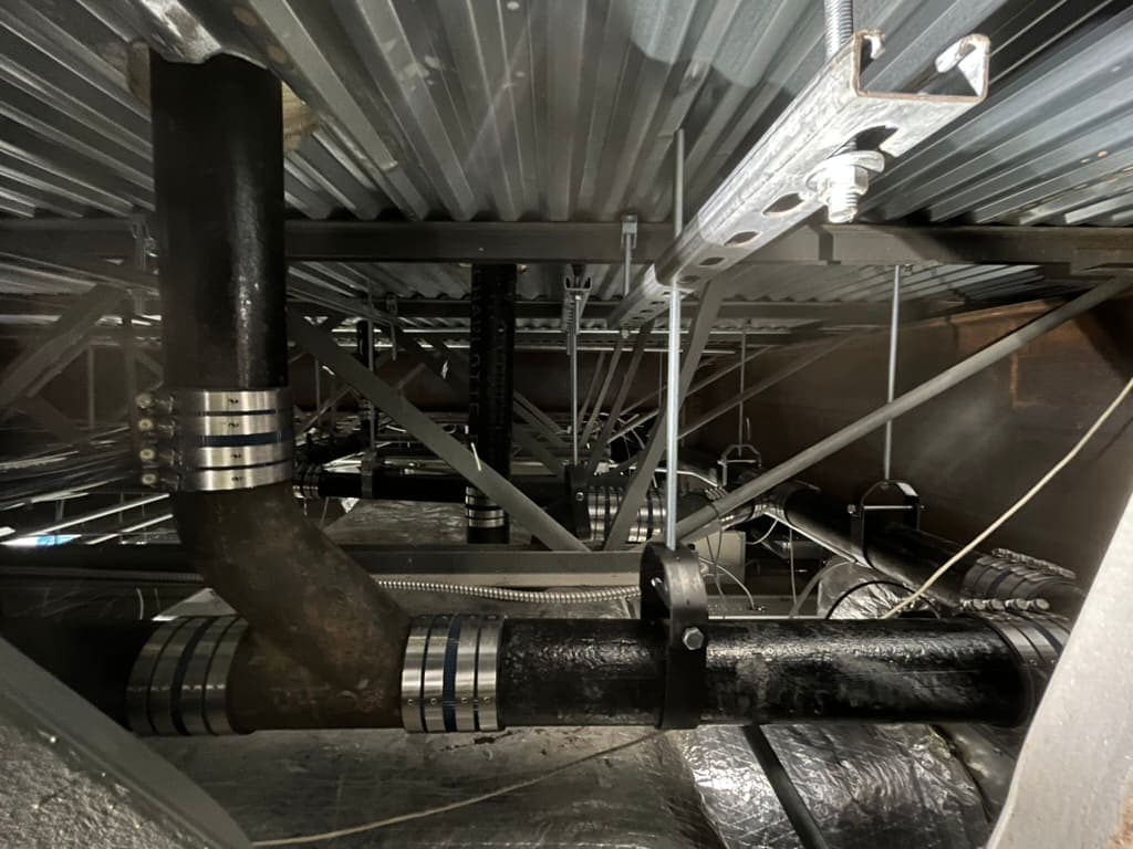 Cast-iron drain lines in a commercial ceiling, a plumbing job by MRJ Plumbing in the Asheville, NC area