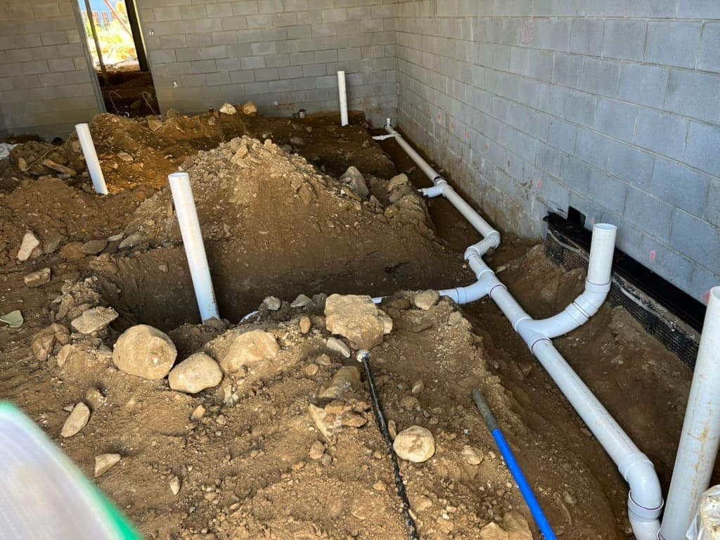 Drain piping in an excavated basement floor, a plumbing job by MRJ Plumbing in the Asheville, NC area